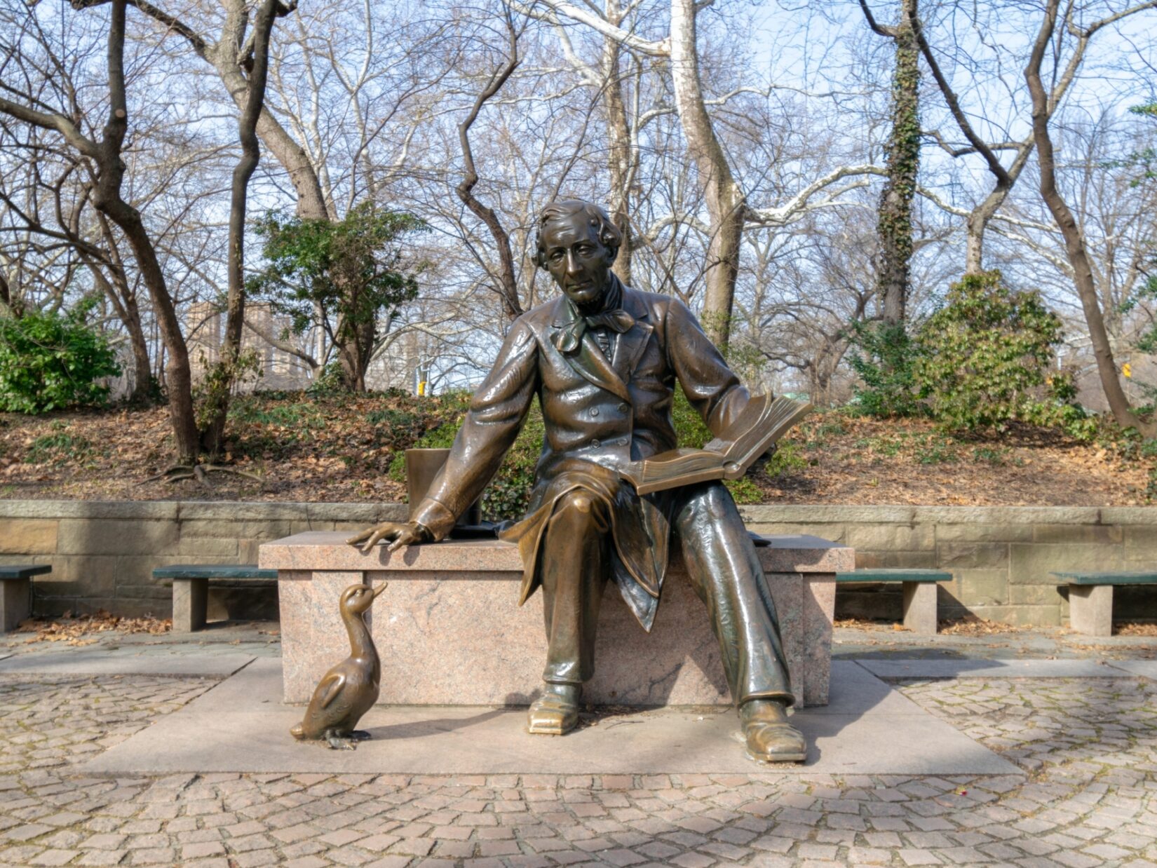 The sculpture of the author is viewed by a sculpture of an ugly duckling