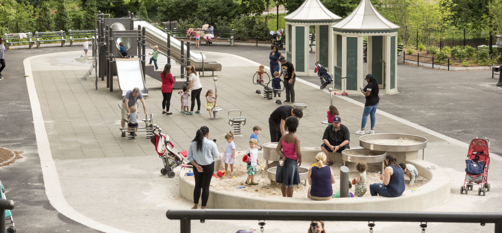 Children and guardians enjoying the playground in summer